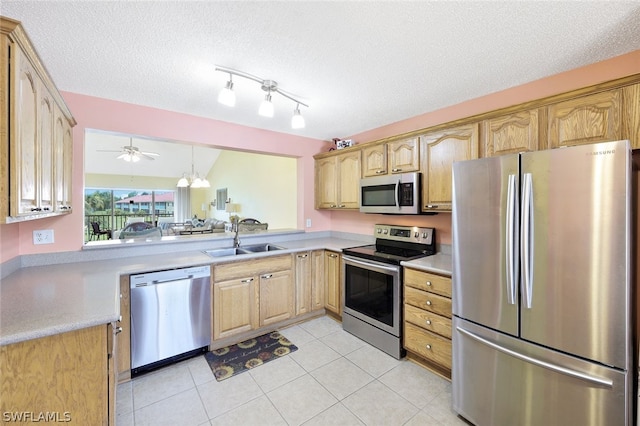 kitchen featuring sink, ceiling fan, light tile patterned floors, a textured ceiling, and appliances with stainless steel finishes