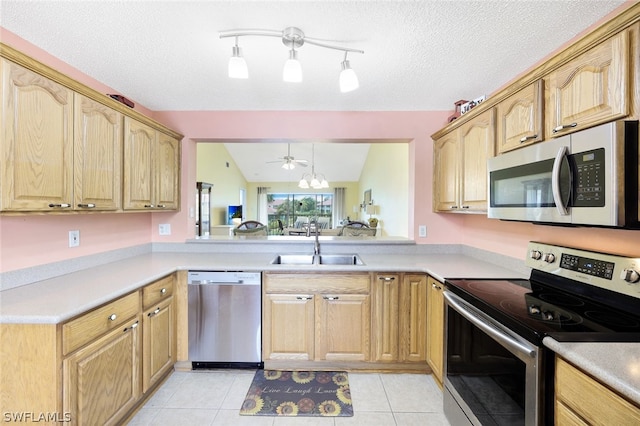 kitchen featuring appliances with stainless steel finishes, vaulted ceiling, ceiling fan, sink, and light tile patterned floors