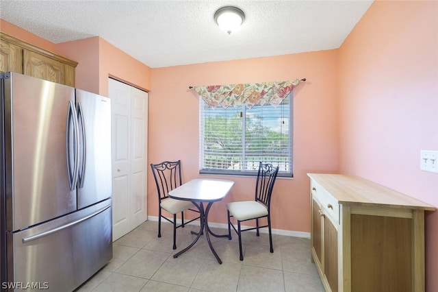 dining area featuring light tile patterned floors and a textured ceiling