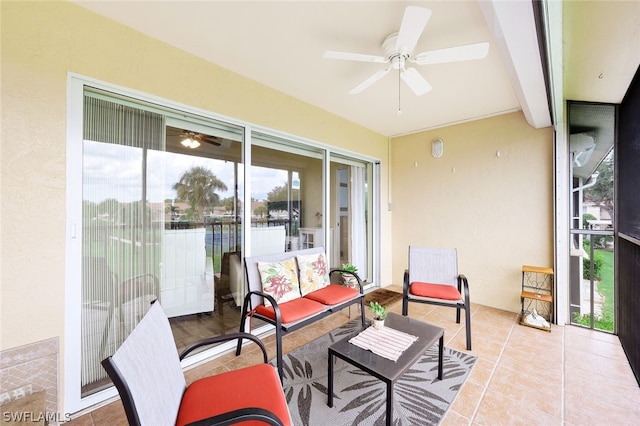 sunroom featuring ceiling fan and beam ceiling