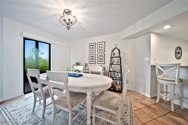 tiled dining space with a notable chandelier