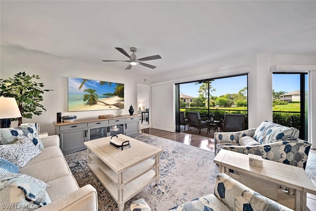 living room with ceiling fan and dark hardwood / wood-style flooring