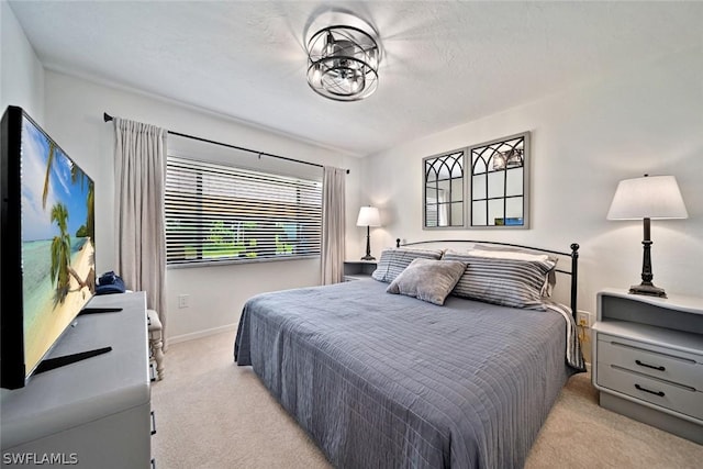 bedroom featuring light colored carpet and a textured ceiling