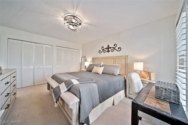 carpeted bedroom featuring two closets