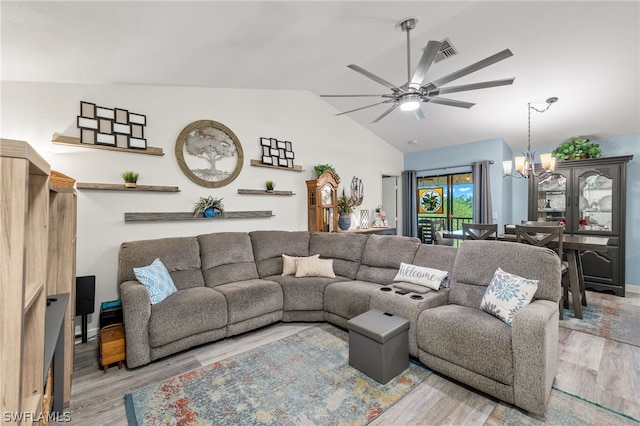 living room featuring light wood-type flooring, vaulted ceiling, and ceiling fan with notable chandelier