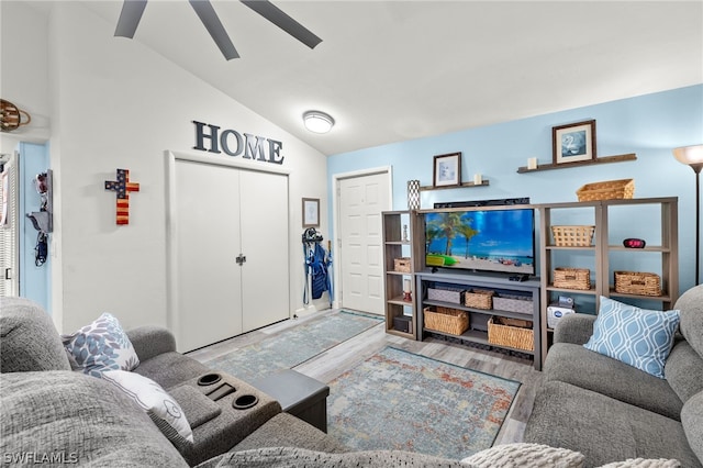 living room with ceiling fan, vaulted ceiling, and light hardwood / wood-style flooring