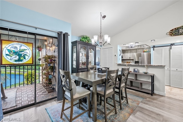 dining space featuring light hardwood / wood-style floors, lofted ceiling, and a chandelier