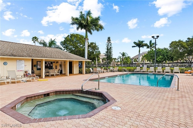 view of swimming pool featuring a patio area and a hot tub