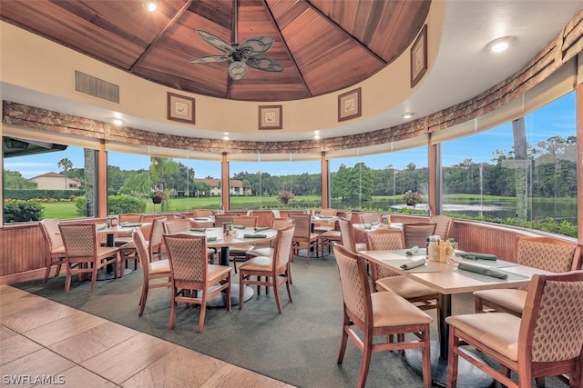 interior space with wooden ceiling, a ceiling fan, visible vents, and a wealth of natural light