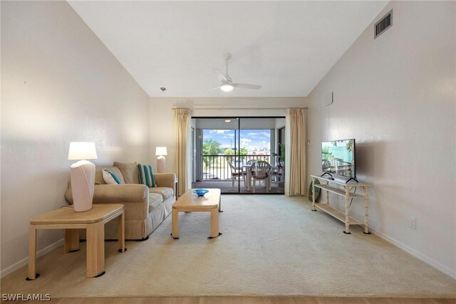 living room featuring ceiling fan, carpet floors, and lofted ceiling