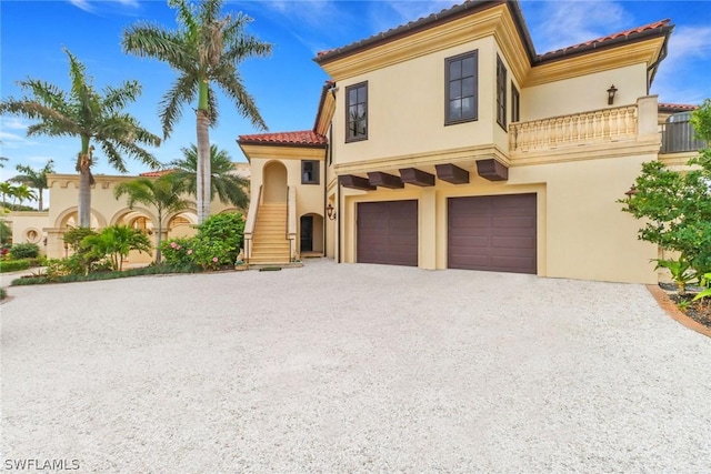 mediterranean / spanish-style home featuring a garage and a balcony