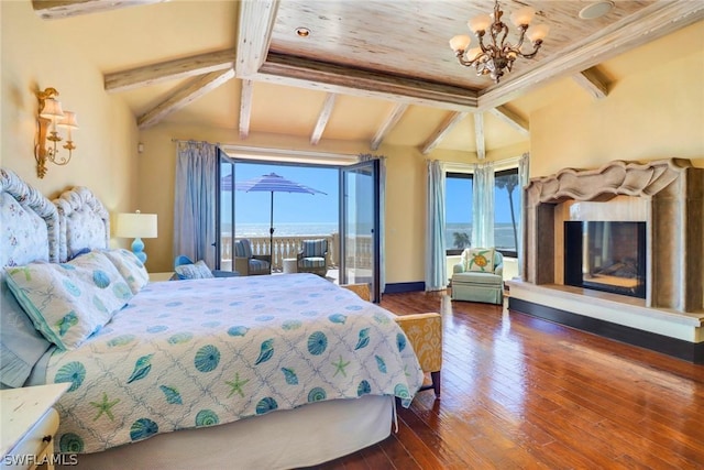 bedroom with a water view, a fireplace, dark hardwood / wood-style floors, and multiple windows