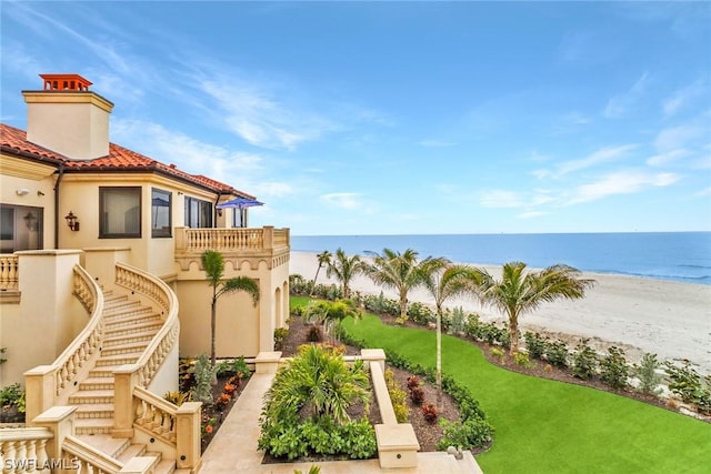 view of yard with a beach view and a water view