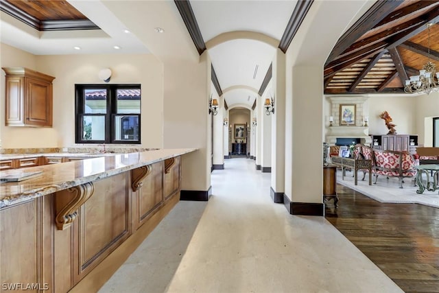 interior space with beamed ceiling, sink, and light hardwood / wood-style floors