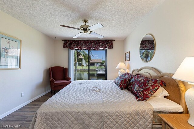 bedroom with ceiling fan, dark hardwood / wood-style floors, and a textured ceiling