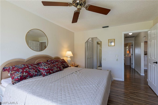 bedroom with ceiling fan, dark hardwood / wood-style flooring, and a textured ceiling