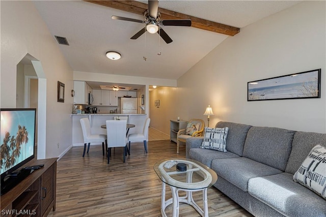 living room featuring hardwood / wood-style floors, vaulted ceiling with beams, and ceiling fan