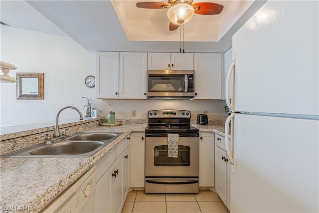 kitchen featuring white cabinetry, sink, stainless steel appliances, a raised ceiling, and light tile patterned floors