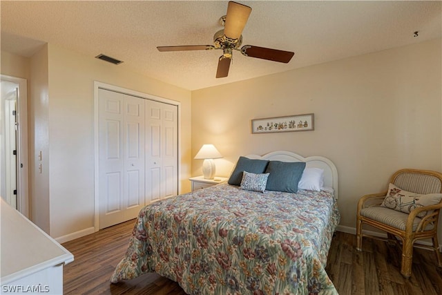 bedroom with a textured ceiling, dark hardwood / wood-style floors, a closet, and ceiling fan