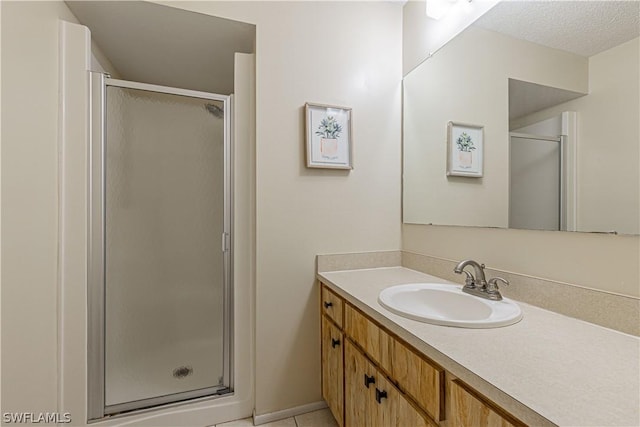 bathroom featuring tile patterned floors, vanity, and a shower with shower door