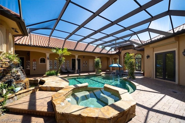 view of pool with pool water feature, an in ground hot tub, glass enclosure, and a patio