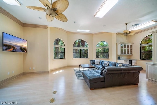 living room with crown molding, ceiling fan, and light hardwood / wood-style flooring