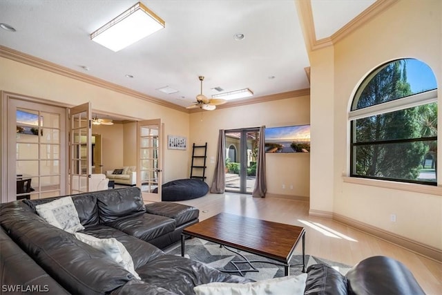 living room featuring ornamental molding, french doors, ceiling fan, and light wood-type flooring