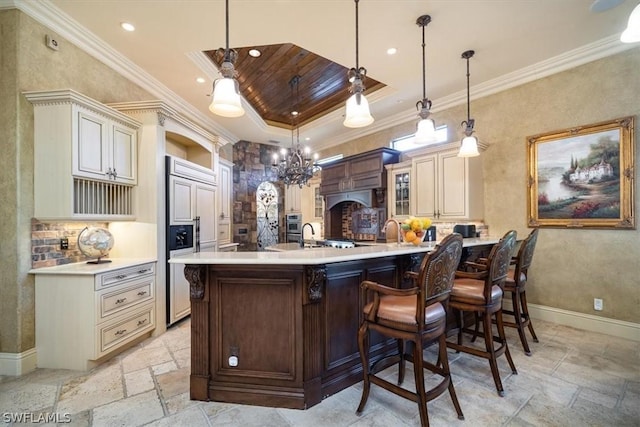 bar with pendant lighting, paneled fridge, cream cabinetry, and crown molding