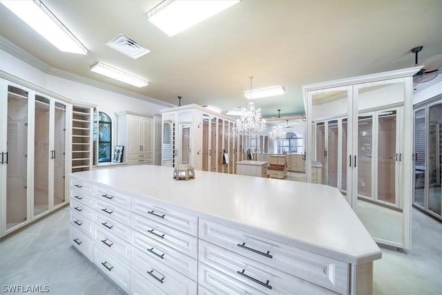 spacious closet with an inviting chandelier