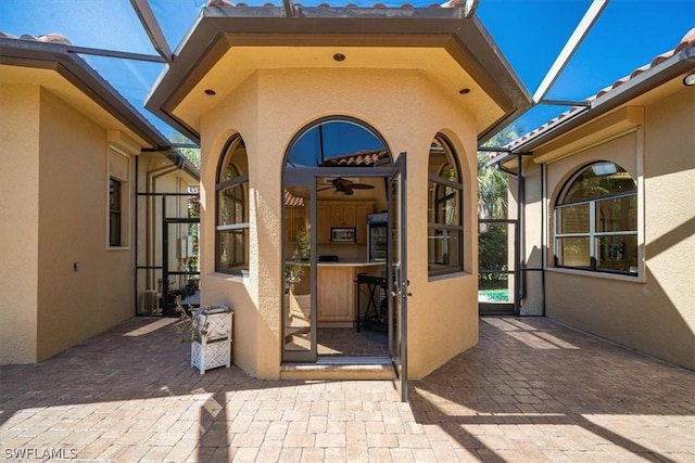 view of patio featuring a lanai and ceiling fan