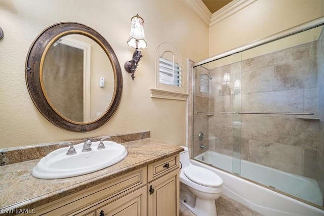 full bathroom featuring ornamental molding, bath / shower combo with glass door, vanity, and toilet