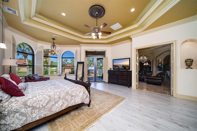 bedroom with ornamental molding, a raised ceiling, ceiling fan, and wood-type flooring