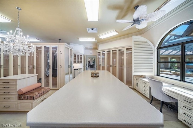 kitchen featuring white cabinets, ornamental molding, ceiling fan with notable chandelier, a kitchen island, and pendant lighting