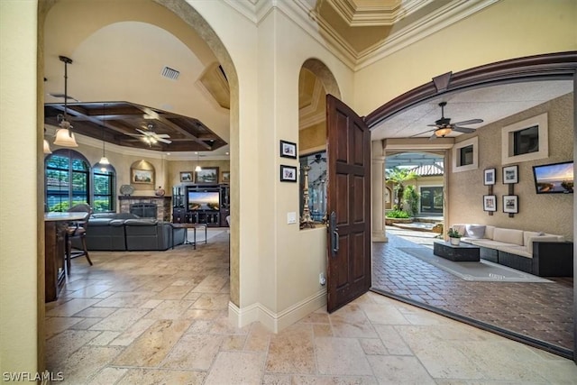 foyer entrance featuring a high ceiling, ceiling fan, crown molding, and coffered ceiling