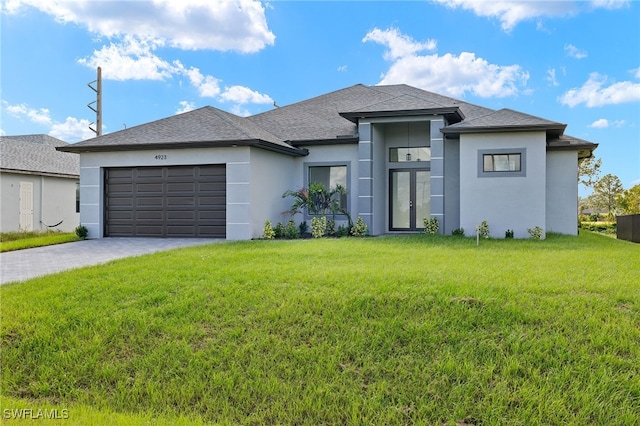 prairie-style home featuring stucco siding, an attached garage, decorative driveway, and a front lawn