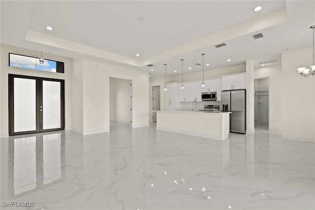 unfurnished living room with light marble finish flooring, a tray ceiling, baseboards, and recessed lighting