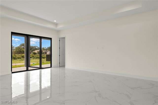 spare room featuring light marble finish floors, a raised ceiling, baseboards, and recessed lighting