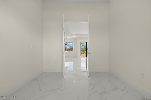 spare room with baseboards and marble look tiles