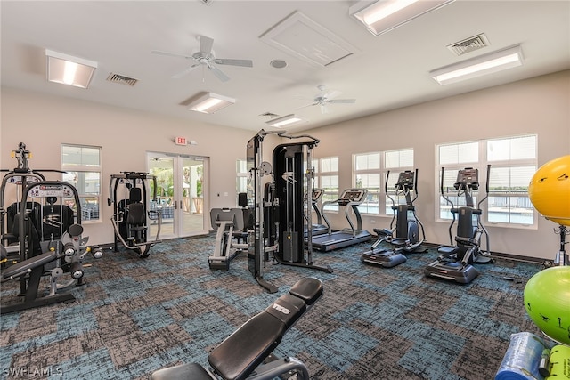 gym with ceiling fan, french doors, a healthy amount of sunlight, and dark carpet