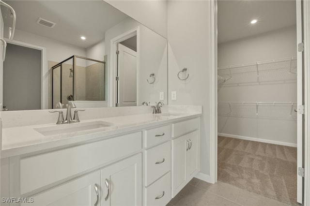 bathroom featuring tile patterned flooring, vanity, and walk in shower