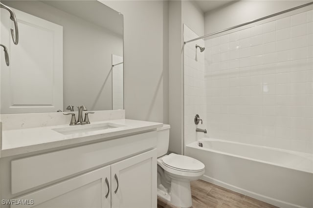 full bathroom with bathing tub / shower combination, hardwood / wood-style floors, vanity, and toilet