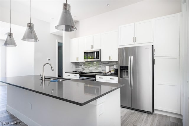 kitchen featuring a center island with sink, light wood-type flooring, white cabinets, sink, and appliances with stainless steel finishes