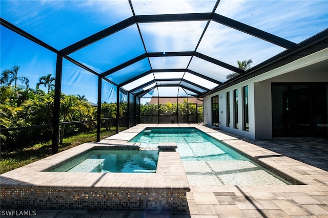 view of swimming pool with a patio, glass enclosure, and an in ground hot tub