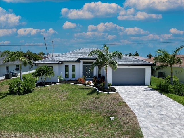 view of front of home with a front yard, a garage, and central AC unit