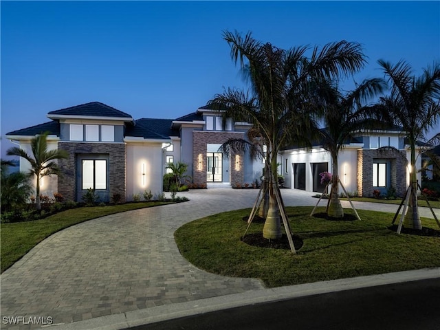 view of front of home featuring a lawn and a garage