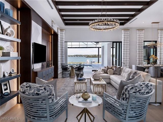 living room featuring beamed ceiling, a chandelier, and light hardwood / wood-style flooring