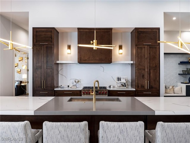 kitchen featuring tasteful backsplash, fridge, a kitchen bar, and pendant lighting