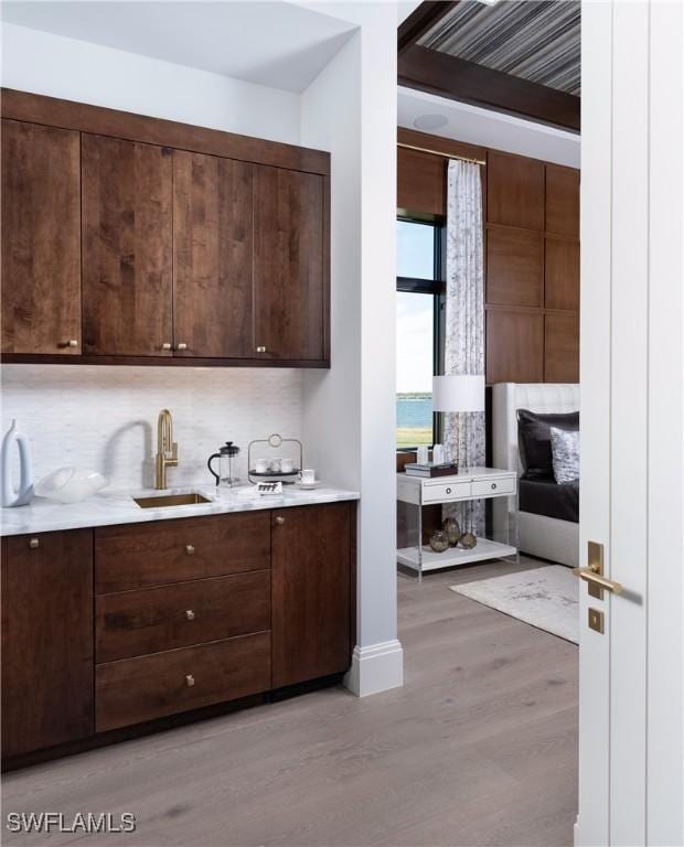 kitchen with dark brown cabinetry, sink, and light hardwood / wood-style floors