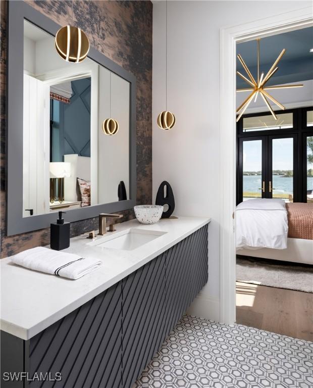 bathroom featuring vanity, a water view, and french doors