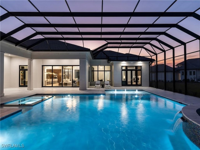 view of swimming pool with an in ground hot tub, pool water feature, and glass enclosure